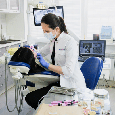 History of orthodontics: how treatment has changed over the years 3 A woman in a white coat and mask working on a patient, representing the history of orthodontics